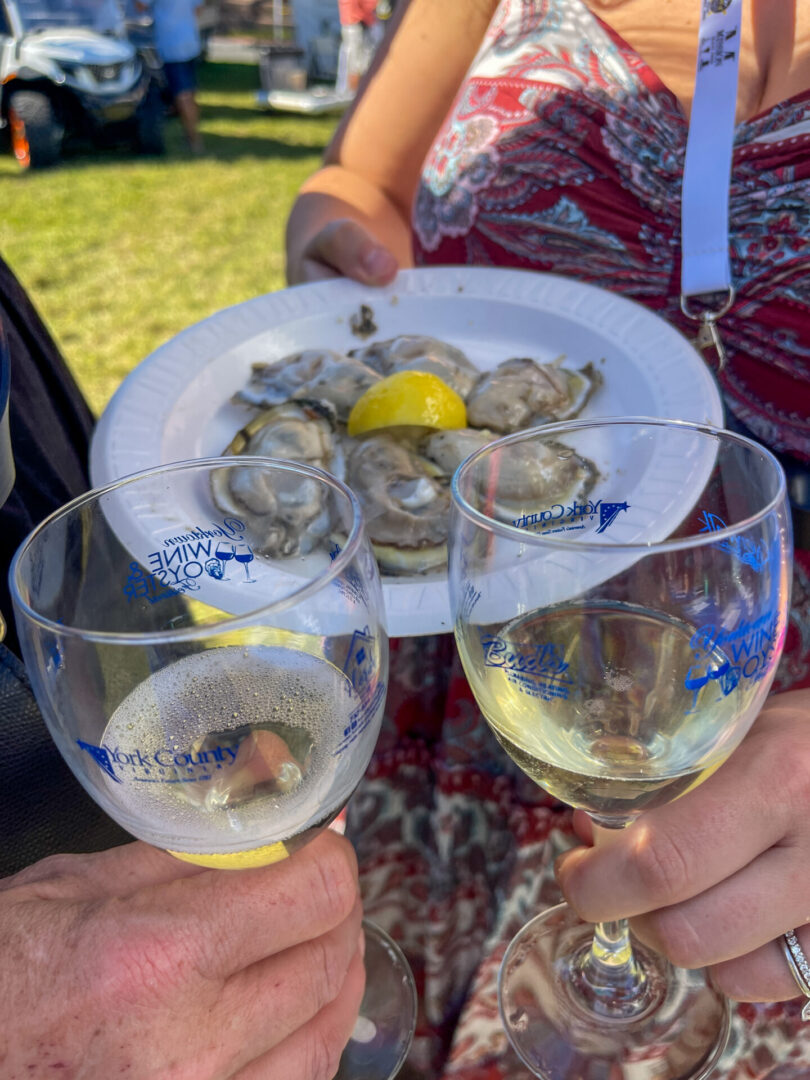 Man and woman holding glasses with white wine and oysters